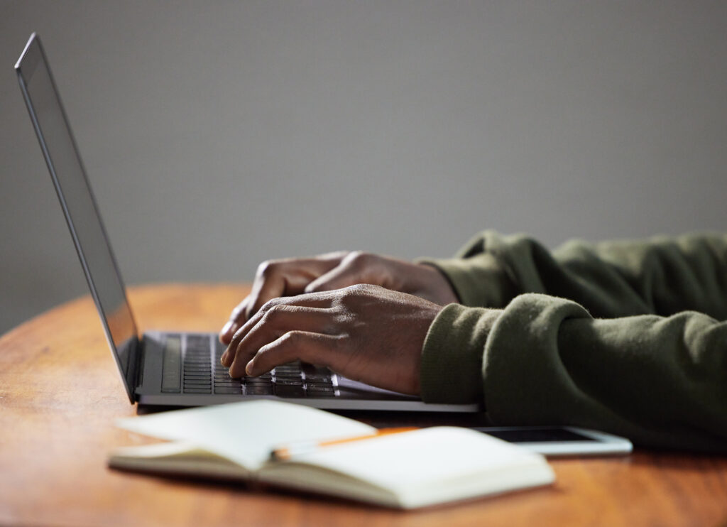 Researching immigration requirements on a laptop, with notes beside it.